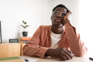 Man in glasses looking stressed and uncertain, representing concerns about how long it takes to receive a bankruptcy discharge in Florida after filing for bankruptcy relief.